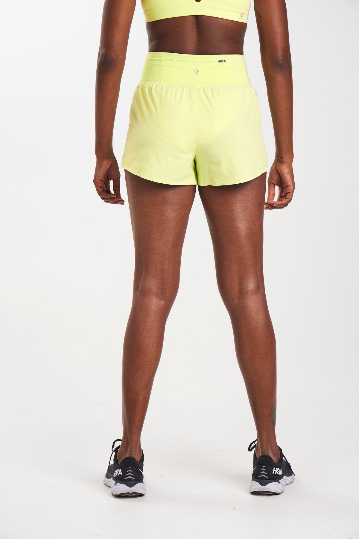 Back view of sustainable running shorts in color stem (yellow)