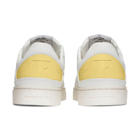 back view of white sustainable alternative to nike shoes with pastel yellow details 