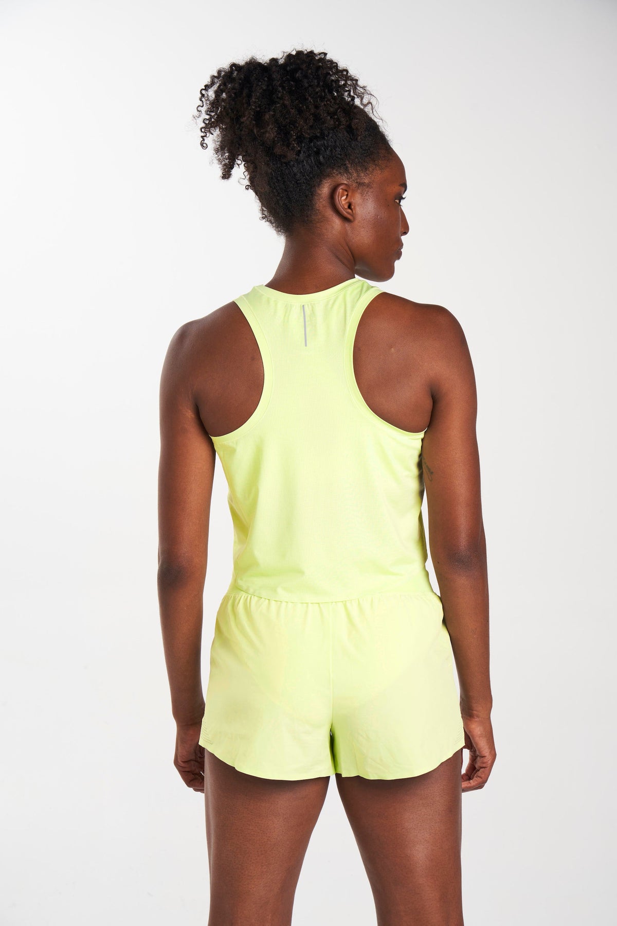 Back view of eco-friendly mesh workout tank top in color Stem (yellow). Breathable and lightweight, perfect for active lifestyles.