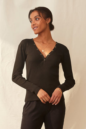 quiet luxury black henley with gold details made from sustainable materials