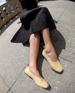 minimalist leather flats made from sustainable materials in yellow